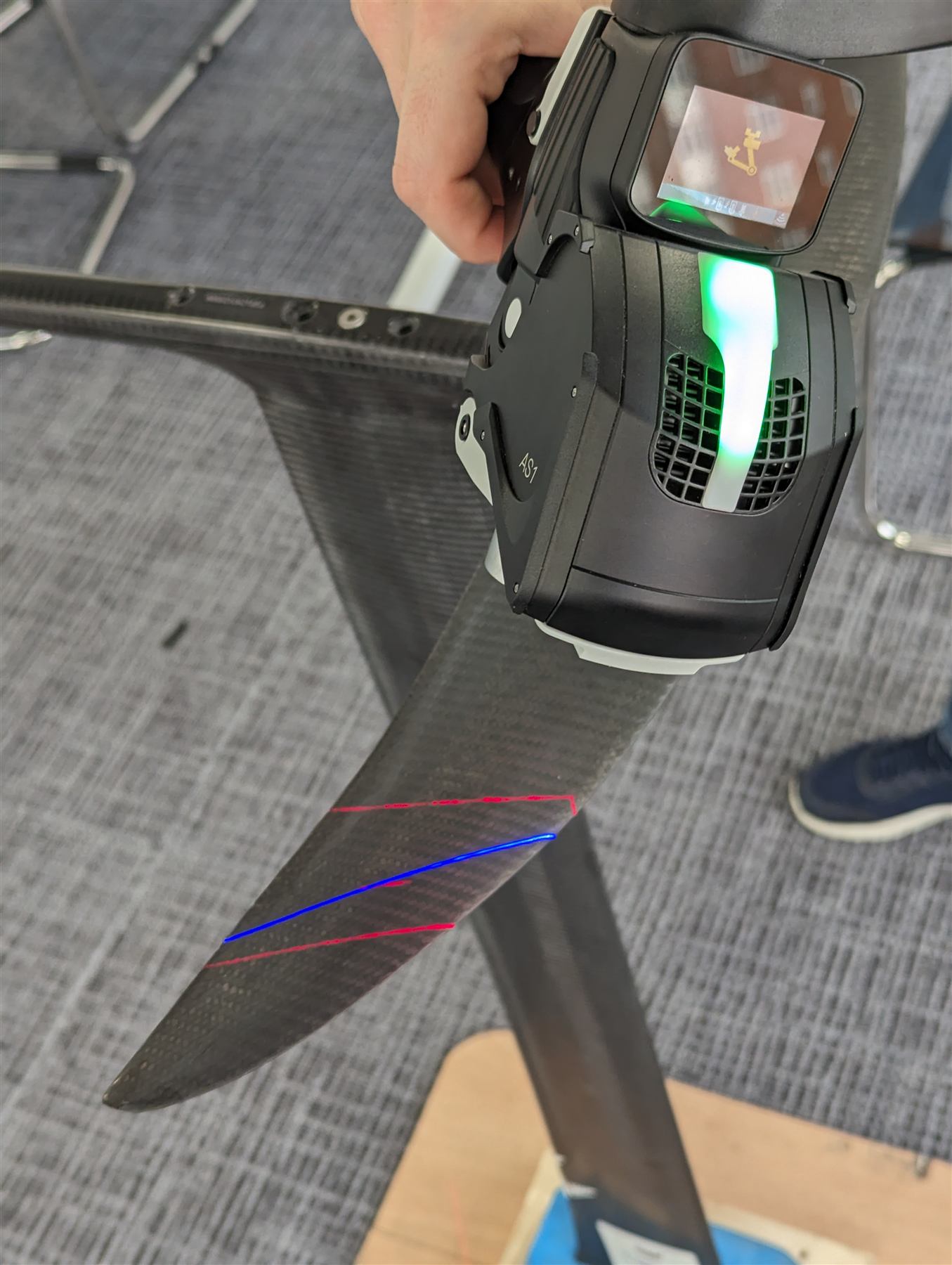 Laser-scanning a carbon hydrofoil, with a blue and red alignment overlay tracking surface deviation against the functional datum.